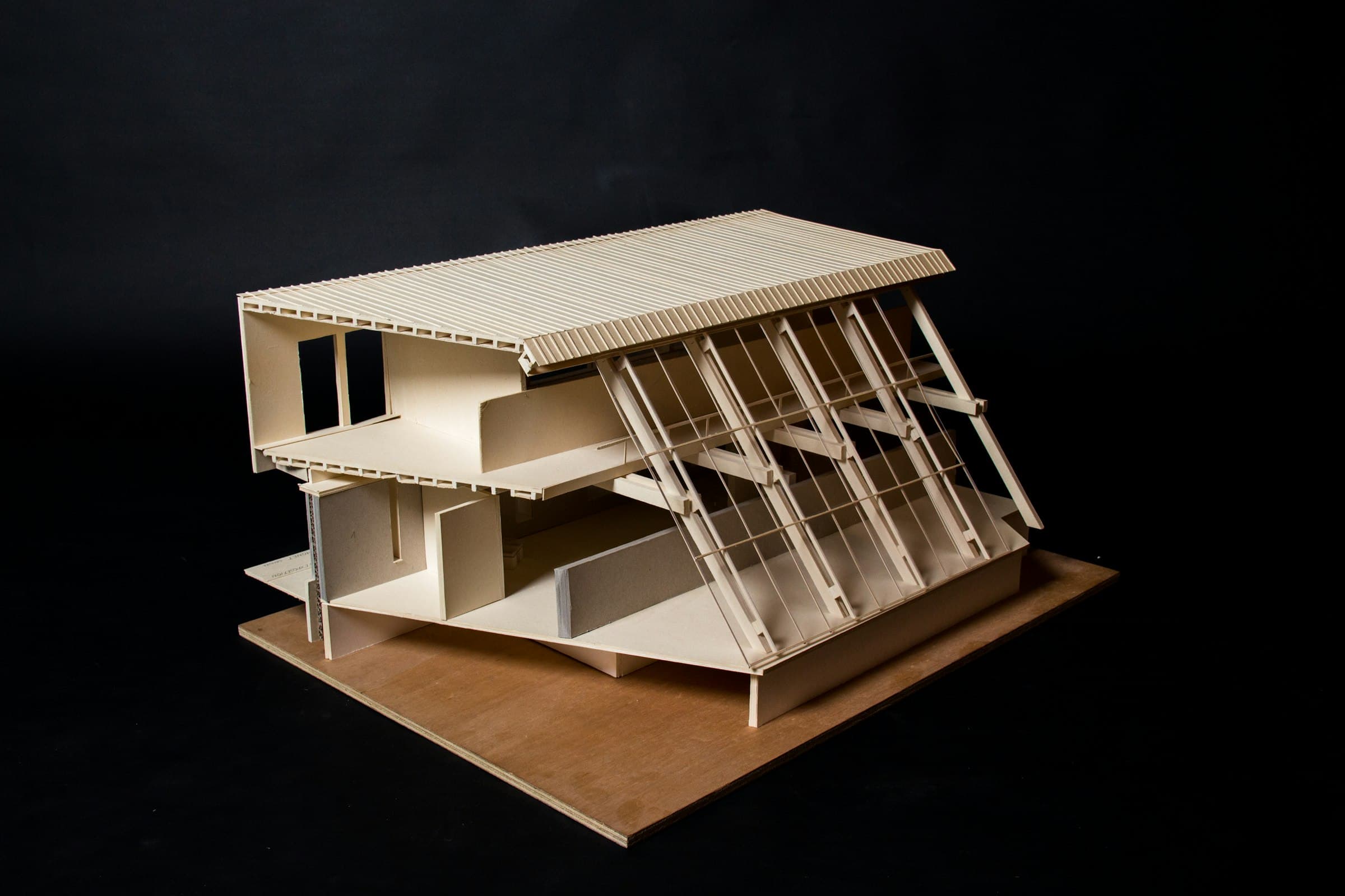 A white architectural model of a building on a black background
