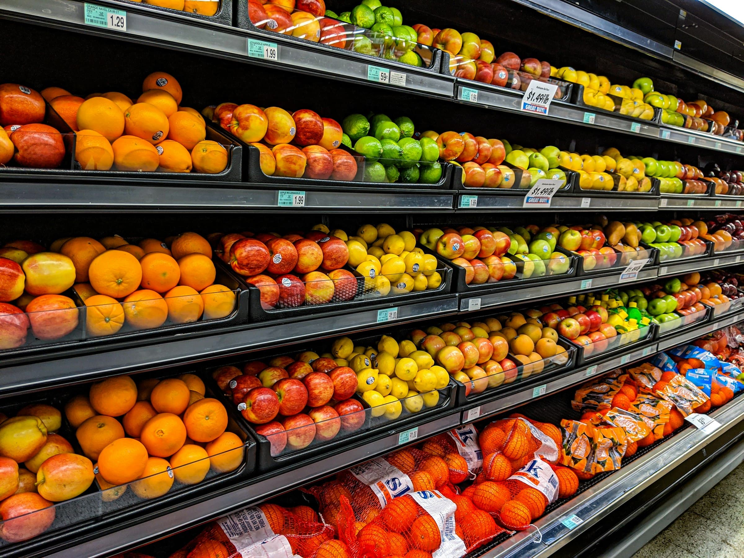 Shelves of oranges, apples and pears in a grocery store's produce aisle