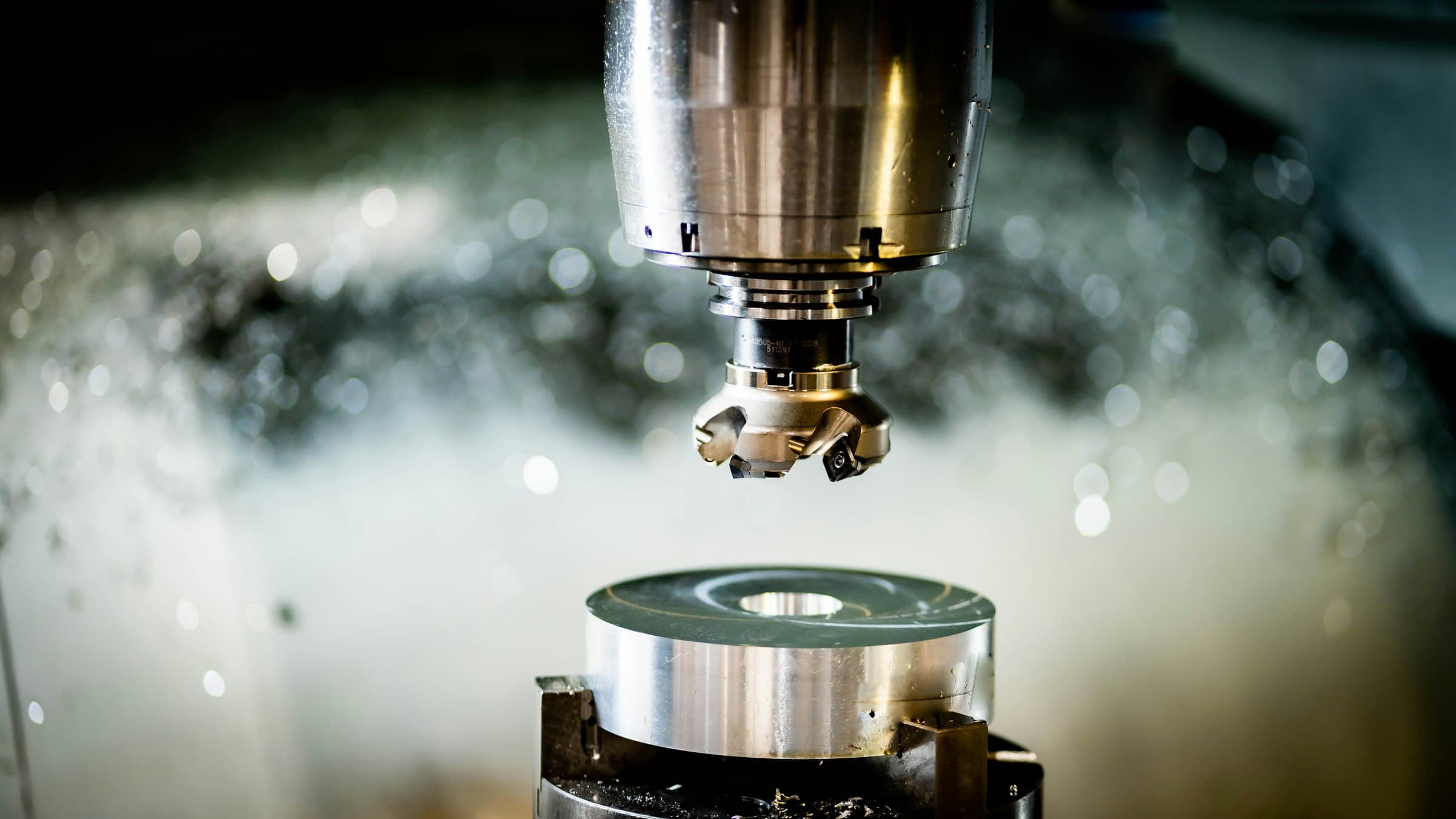 A CNC milling machine cutting a metal part as coolant sprays