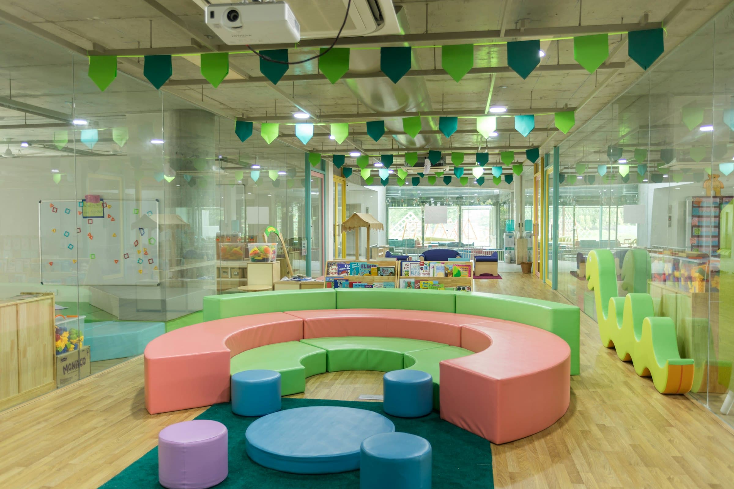 A day care center's play area with soft colored seating and bunting