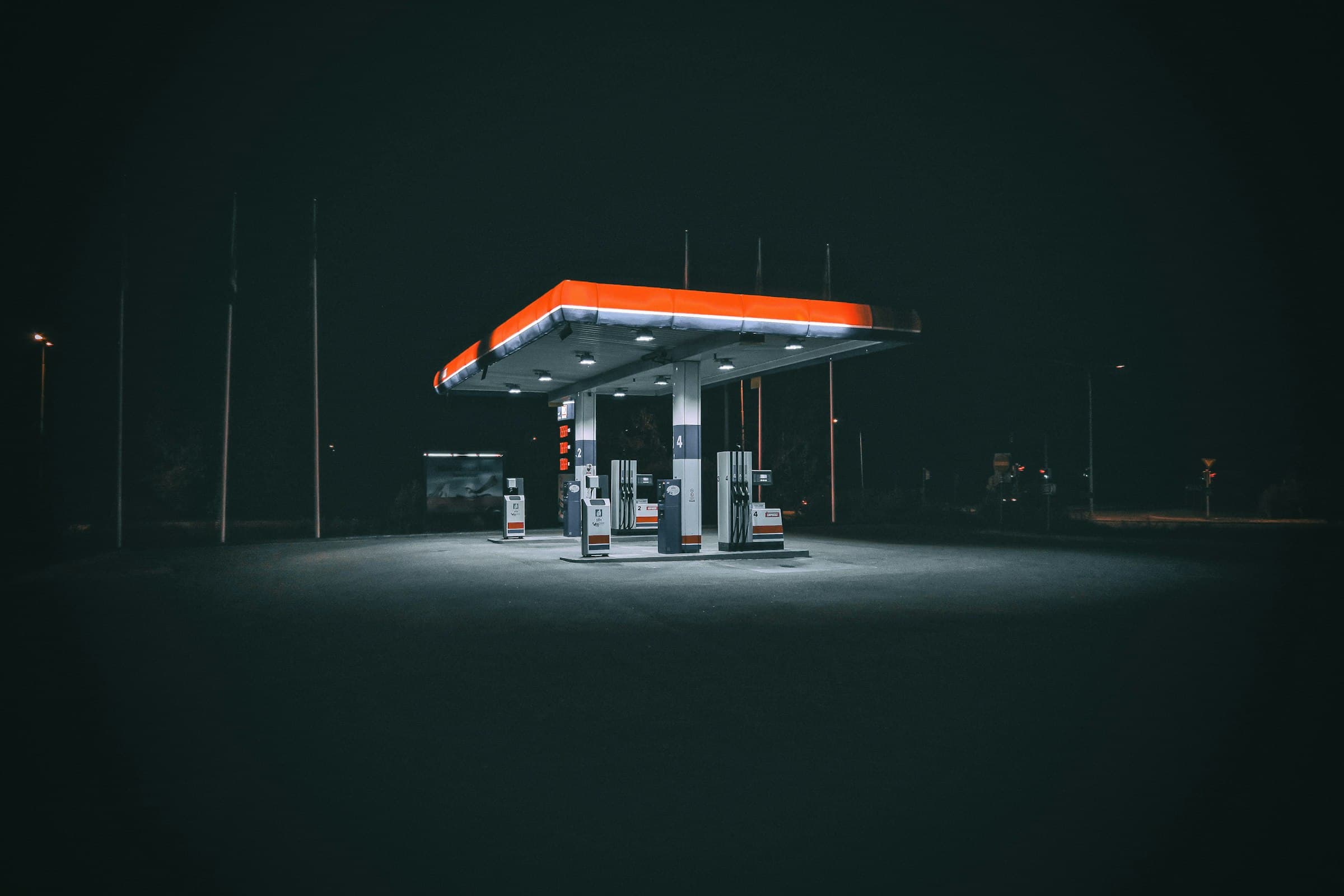 A lone gas station glowing under its canopy lights at night